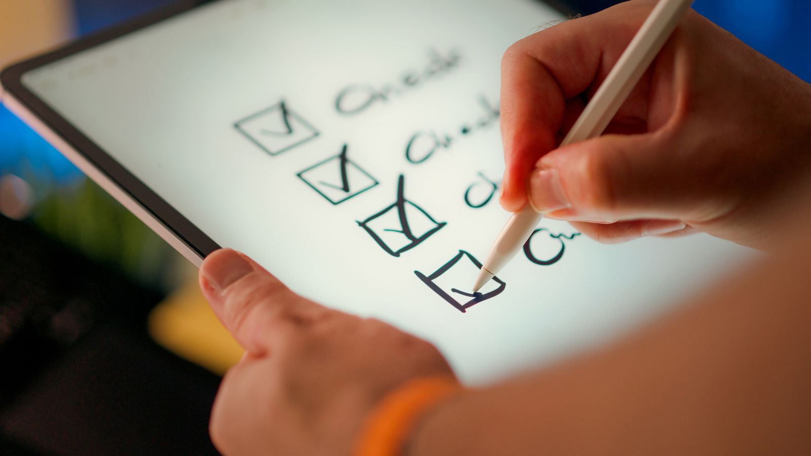 Hand checking off items on a checklist on a tablet with a stylus