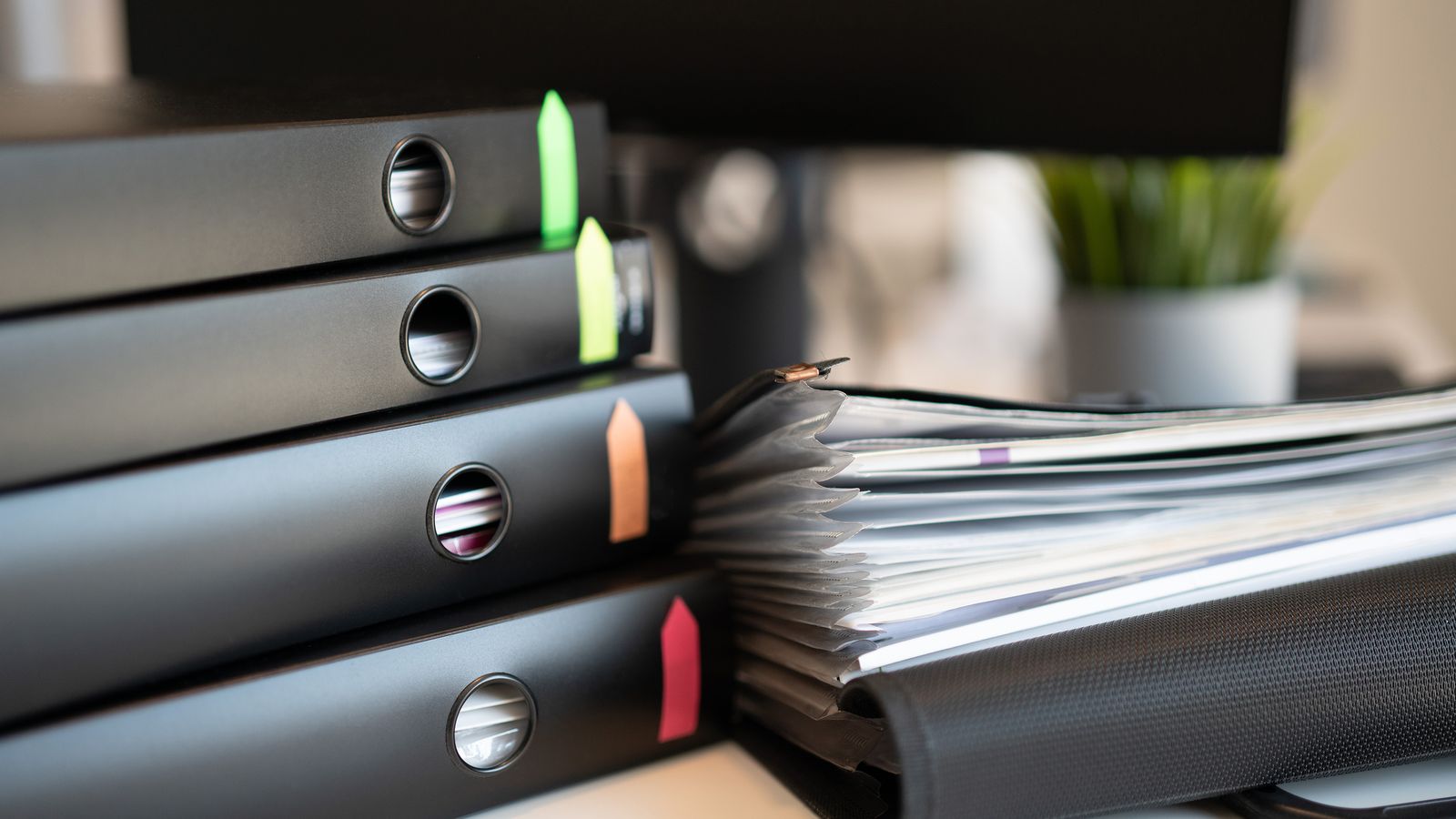 Ring binders of compliance documents on a desk
