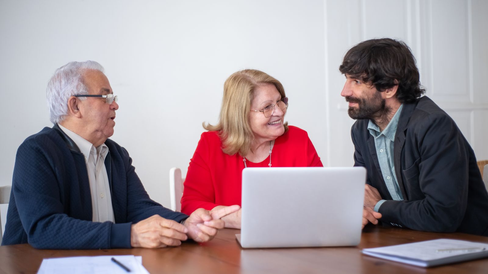 Financial advisor meeting with a couple at a laptop